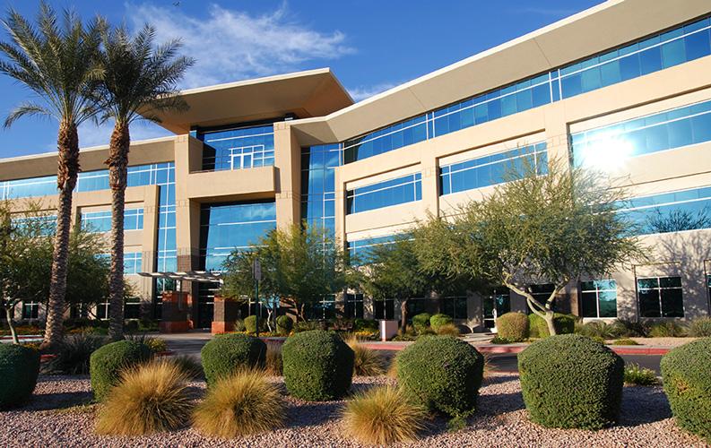 An image of an office building with detailed and beautiful landscaping.